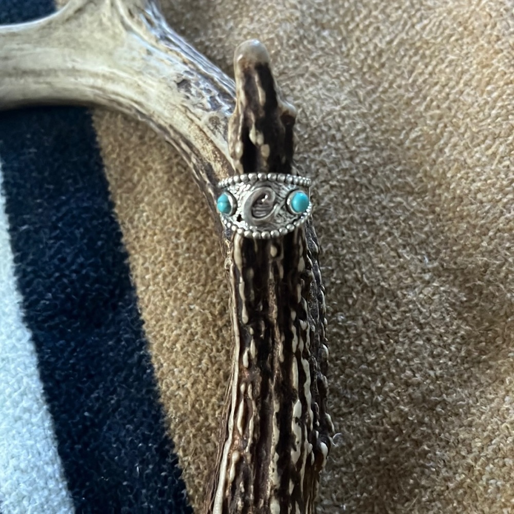Ring with the letter C in the middle and two turquoise stones surrounding it